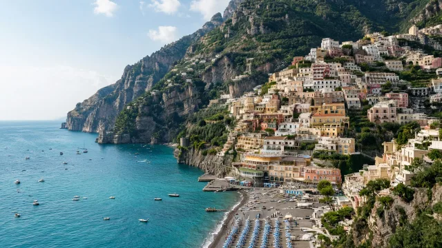 Colourful houses of Positano stacked on cliffs above a beach and turquoise sea on the Amalfi Coast