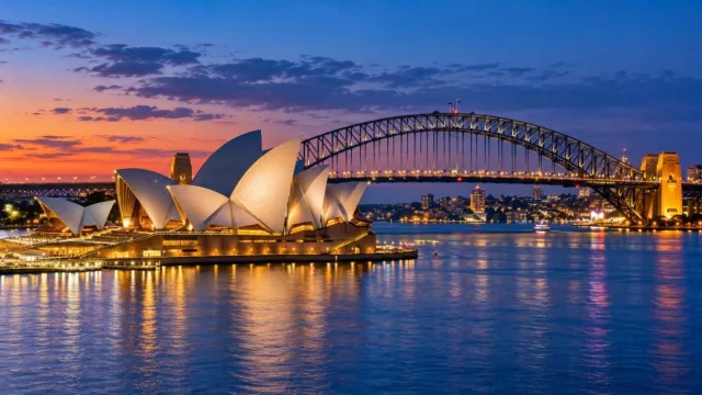 Sydney Opera House and Harbour Bridge at blue hour reflected in calm harbour water