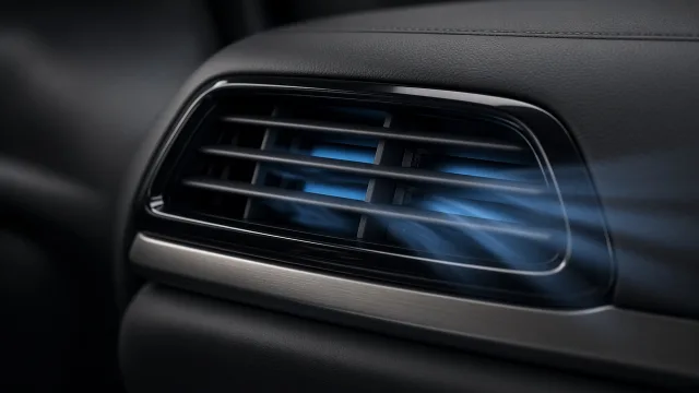 Editorial illustration of cool blue airflow streaming from a car dashboard vent