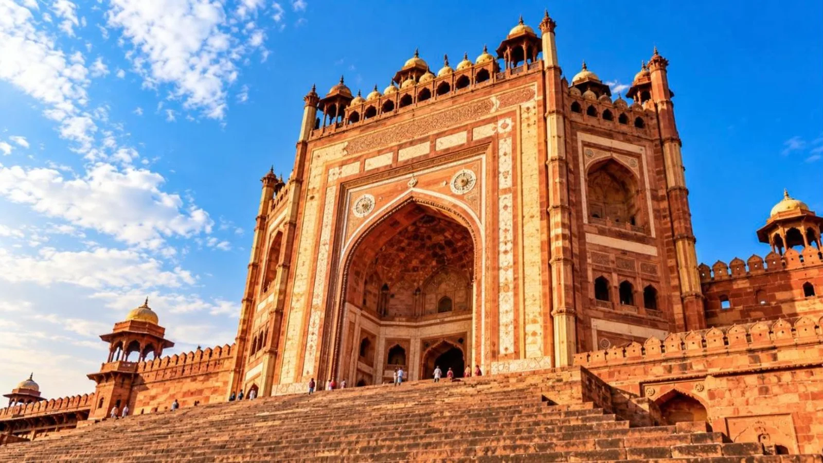 The towering Buland Darwaza gateway of Fatehpur Sikri against a blue sky