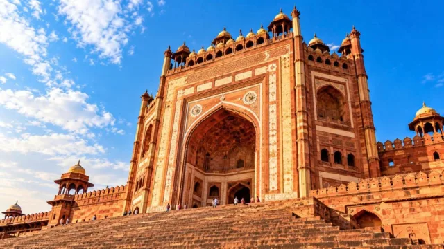The towering Buland Darwaza gateway of Fatehpur Sikri against a blue sky