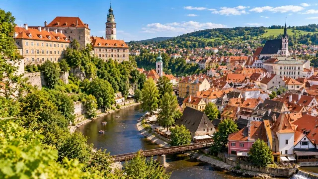 Winding river through a red-roofed medieval Central European town with a castle on a hill